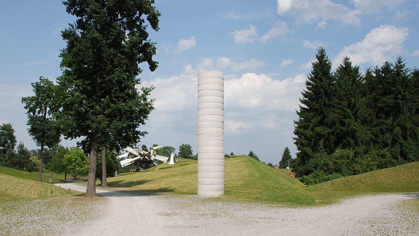 A "pillar" made of precast concrete elements in the entrance area of the sculpture park. The sculpture is deliberately not elaborately or beautifully designed. This keeps the attention on the material itself and allows a sober view of the world.