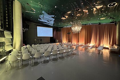 Der Space04 ist für eine Preisverleihung mit Reihenbestuhlung, Podium und Leinwand hergerichtet.