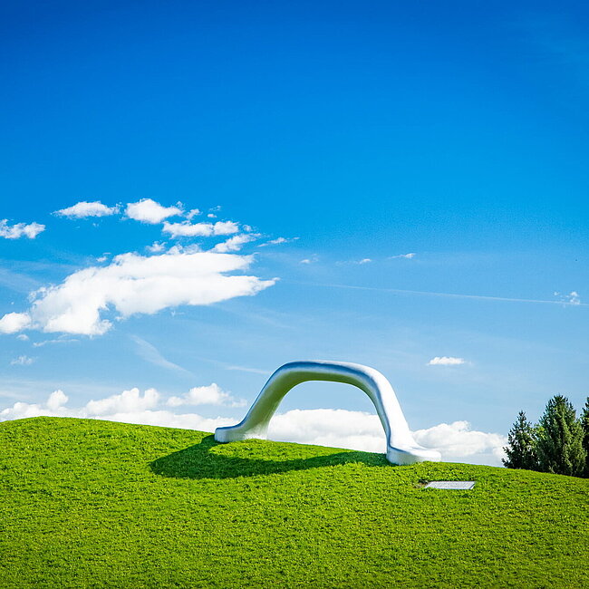 Weitwikliges Panoramabild mit Blick auf die Skulptur "Die Erdkugel als Koffer" und "Sole d'acciaio".