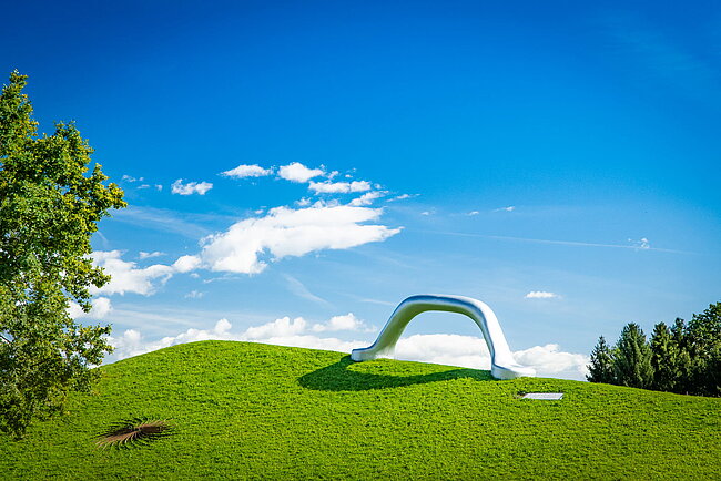 Weitwikliges Panoramabild mit Blick auf die Skulptur "Die Erdkugel als Koffer" und "Sole d'acciaio".