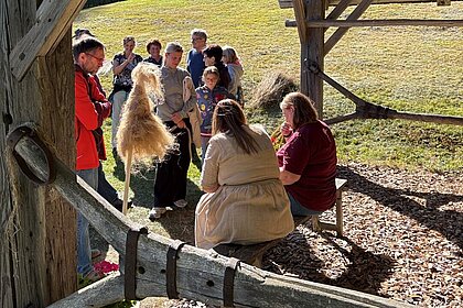 Besucher*innen des Brechelfestes sehen beim Spinnen zu