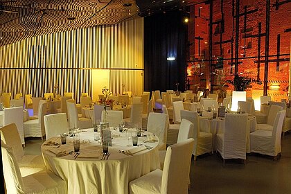 In Space04 are set round gala tables. The room is decorated with color and matching floral decorations.