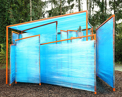 Several large steel brackets protruding from the ground. Originally, these were covered with foil, as can be seen in the picture. The construction is reworked every year by a school class or group of students. 