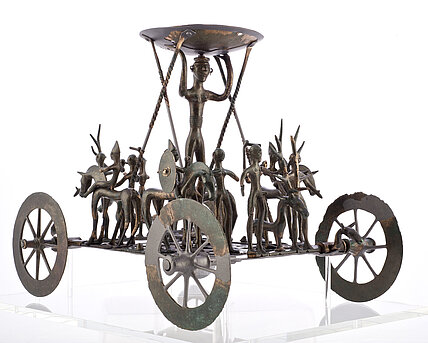 Strettweger Kultwagen: Ein bronzenes Meisterwerk eisenzeitlichen Kunsthandwerks mit einer Prozession aus kleinen menschlichen und tierischen Figuren auf einem Wagen. 