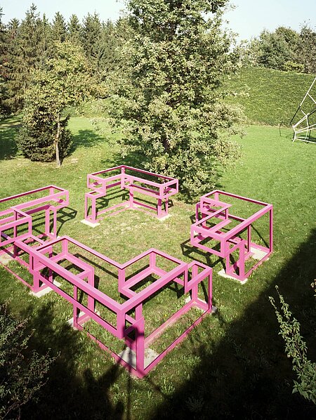 Die Skulptur ist eine große begehbare Struktur aus pink lackiertem Metall. Der Grundriss ist quadratisch, an jeder Seite ist ein "Eingang".