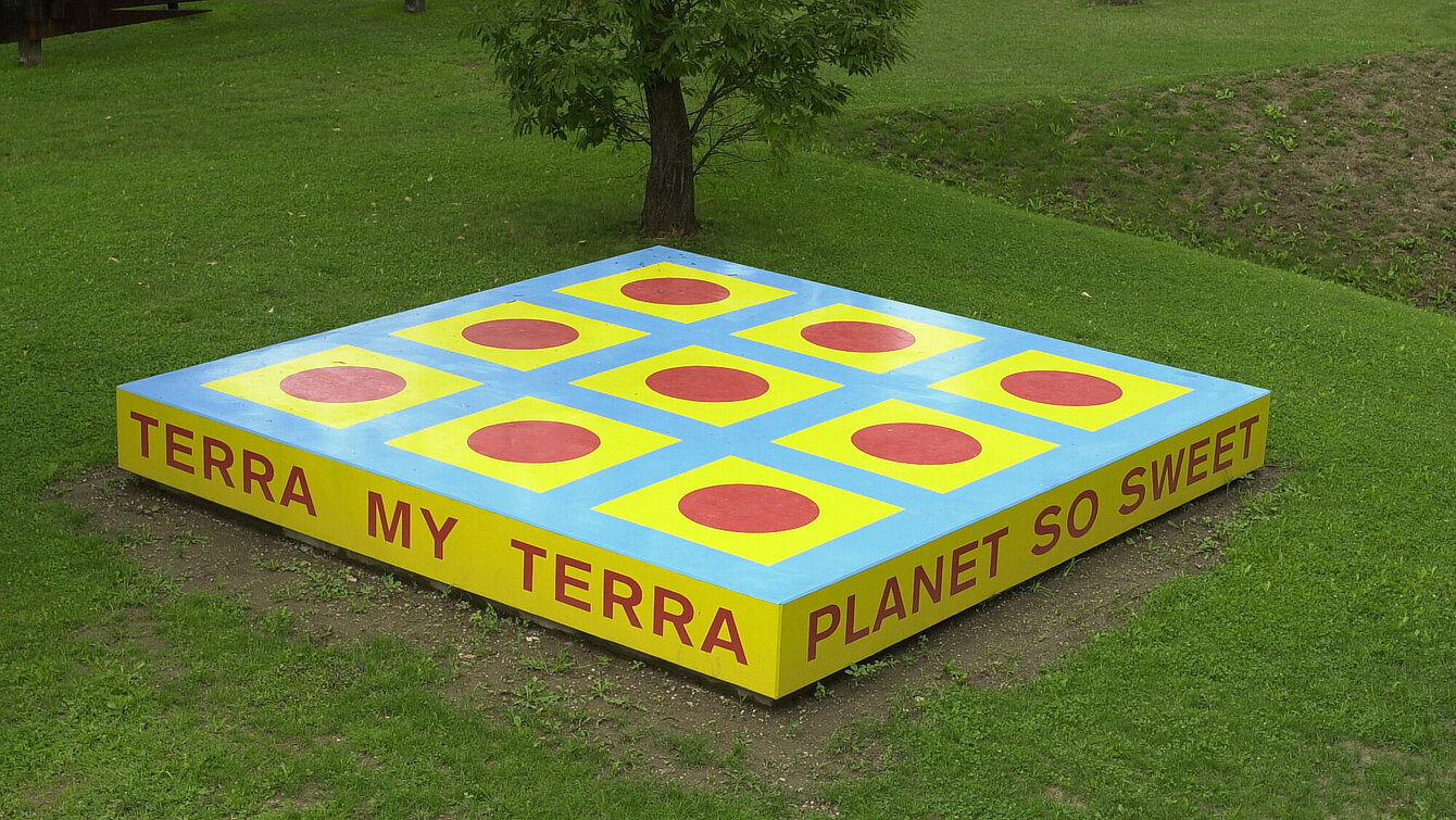 Die Skulptur ist eine Plattform mit der Aufschrift "TERRA MY TERRA/PLANET SO SWEET/I CAN FEEL YOU/UNDER MY FEET".