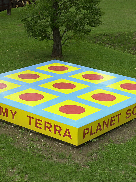 Die Skulptur ist eine Plattform mit der Aufschrift "TERRA MY TERRA/PLANET SO SWEET/I CAN FEEL YOU/UNDER MY FEET".