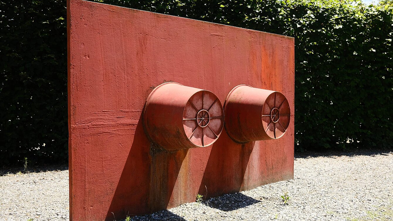 Two metal buckets with their hollow sides fixed to a red metal plate are the basic elements of this sculpture. In the object status of the world of objects, buckets normally stand on the floor. Wurm changes the form of presentation by opening up the base plate and changing the perspective from a floor sculpture to a wall sculpture.