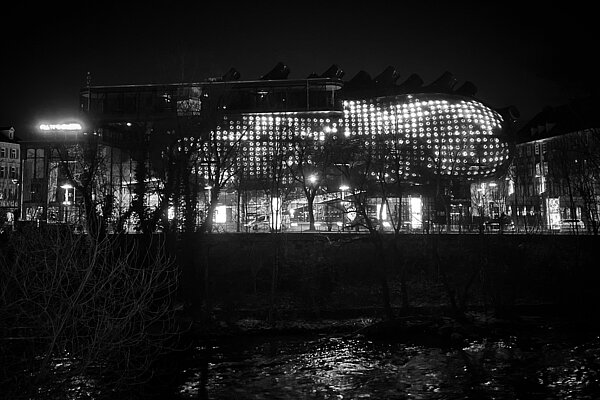 Ein schwarz-weiß Foto der BIX-Medienfassade von der gegenüberliegenden Seite der Mur.