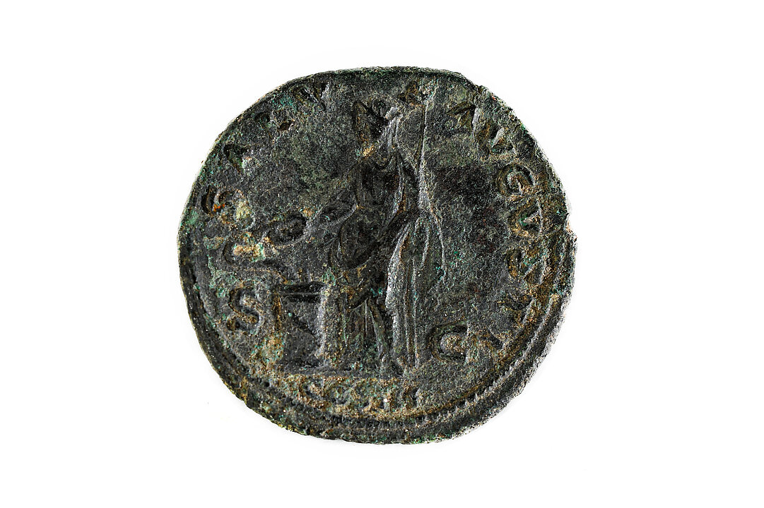 Foto von einer kleinen alten Münze. Ein Mann mit Zepter in der Linken füttert aus einer Opferschale eine Schlange, die sich um einen Altar windet. 