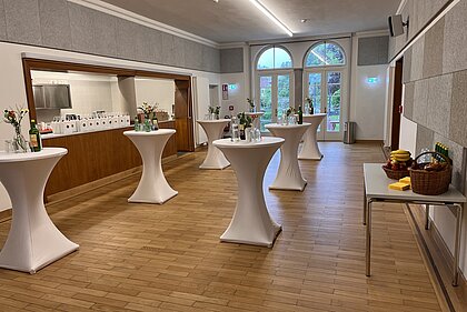 Ein Empfang mit Stehtischen und kleinem Catering ist im Foyer des Heimatsaals aufgebaut.