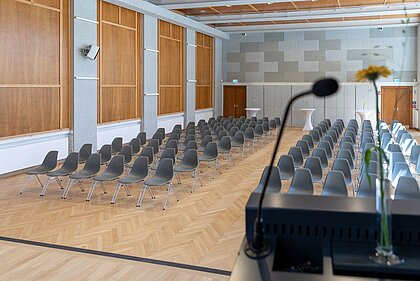 View from the stage in the Heimatsaal in the Folk Life Museum. Chairs are arranged in rows in the room.