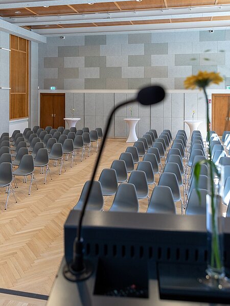 Blick von der Bühne im Heimatsaal im Volkskundemuseum. Im Raum sind Sessel in Reihen angeordnet.