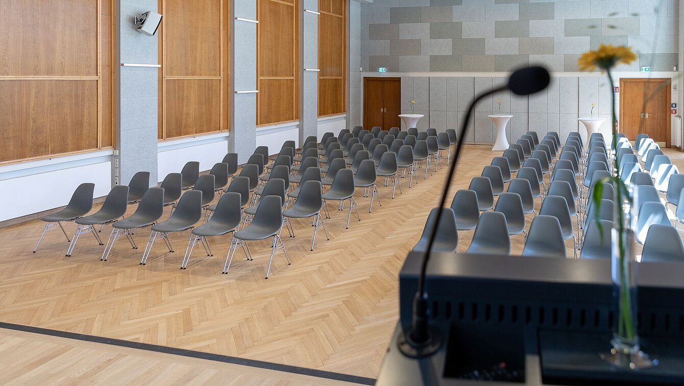 View from the stage in the Heimatsaal in the Folk Life Museum. Chairs are arranged in rows in the room.
