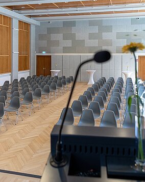 Blick von der Bühne im Heimatsaal im Volkskundemuseum. Im Raum sind Sessel in Reihen angeordnet.