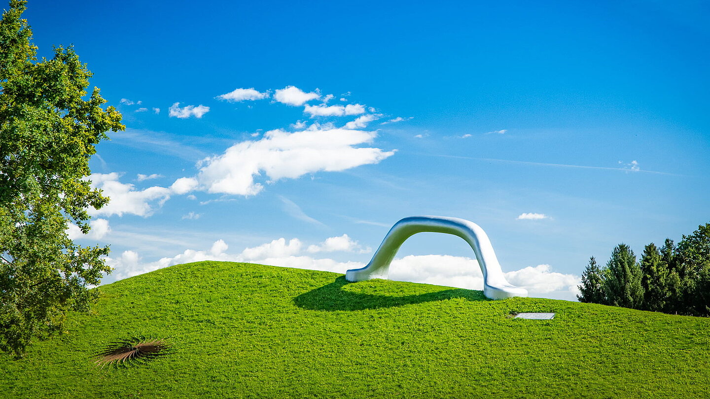 Weitwikliges Panoramabild mit Blick auf die Skulptur "Die Erdkugel als Koffer" und "Sole d'acciaio".