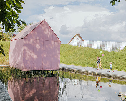 Visitors of the Late Summer Celebration beside the water lily pond in the Austrian Sculpture Park