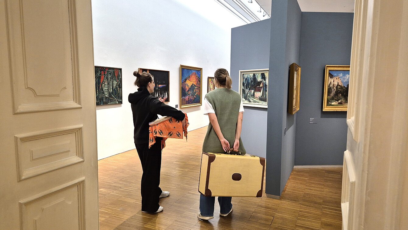 Zwei Kunstvermittlerinnen mit Requisiten in einer Ausstellung