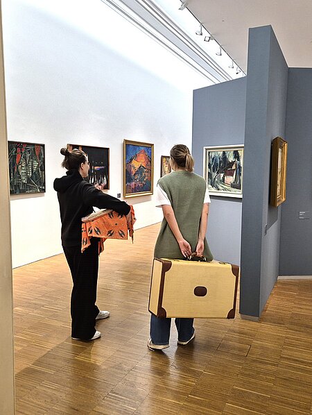 Zwei Kunstvermittlerinnen mit Requisiten in einer Ausstellung