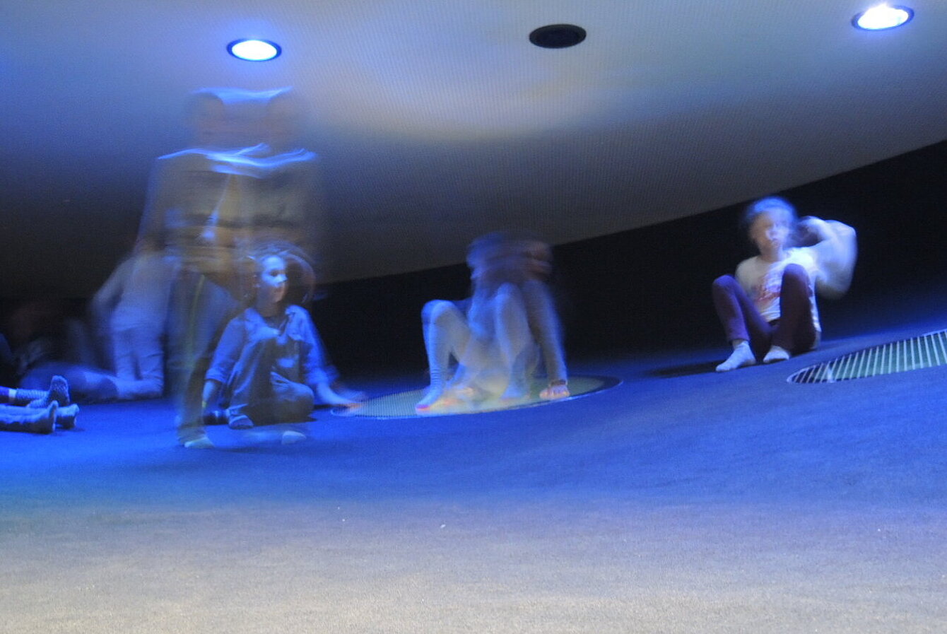 mehrere Kinder in einem dunklen Raum im Kunsthaus