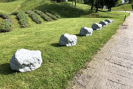 Betonkunstwerk aus 6,4 identischen Steinen die in einer Linie entlang des Weges liegen. 