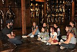 Kindergruppe im Landeszeughaus Zu sehen ist eine sitzende Kindergruppe mit Kulturvermittler im Landeszeughaus. Im Hintergrund sind neuzeitliche Harnische zu sehen.