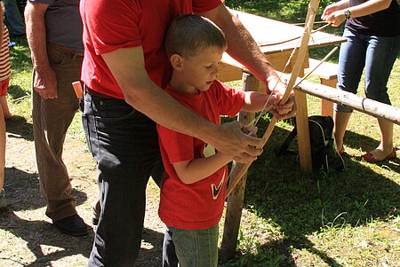 Kind beim Ausprobieren von Pfeil und Bogen 