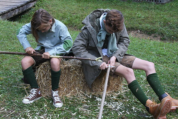 Wanderstecken schnnitzen Kinder beim Schnitzen eines Wandersteckens